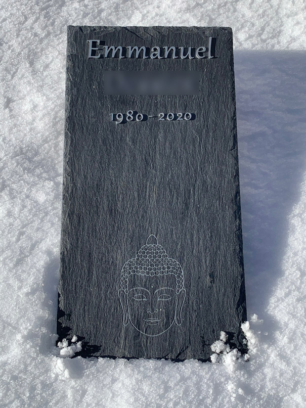 pierre tombale en ardoise sur la neige avec bouddha